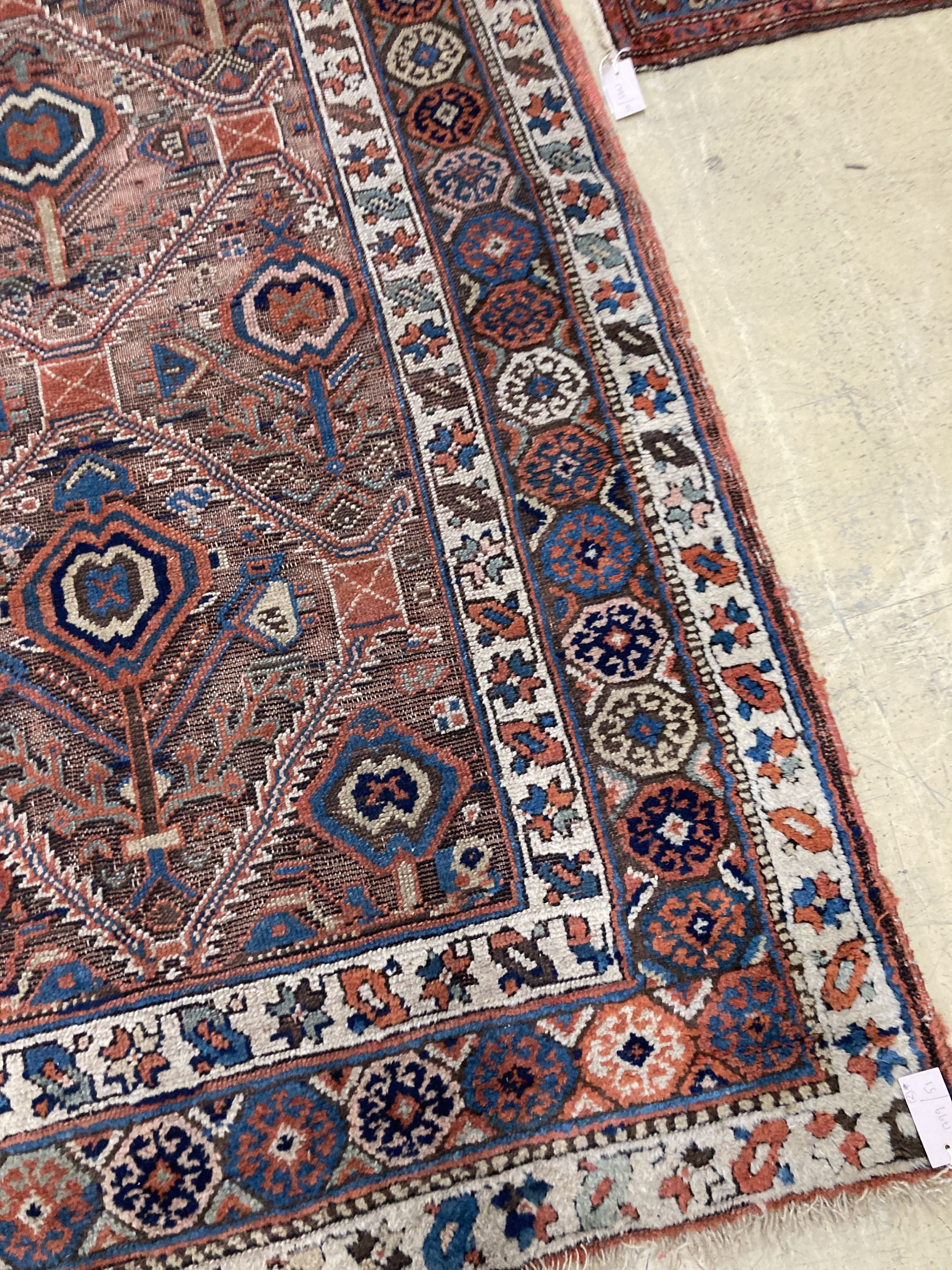 An antique Caucasian red ground rug, 250 x 125 cm and a smaller Shiraz rug.
